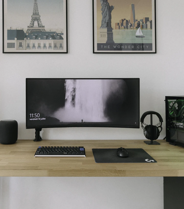 Clean home office with a desktop computer, monitor and keyboard on a wooden desk