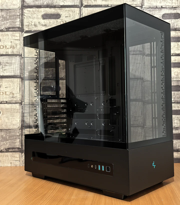 Sleek matte-black PC tower with tinted glass panels on a wooden desk